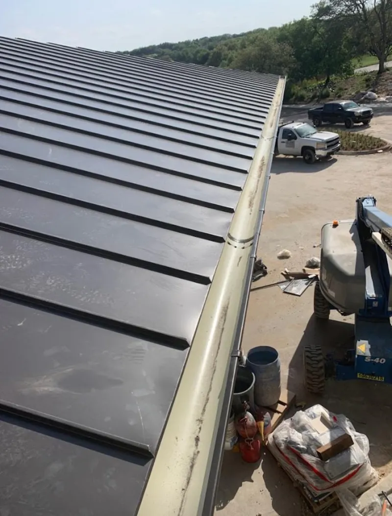 Standing seam panel and gutter detail on a metal roofing jobsite in Morris